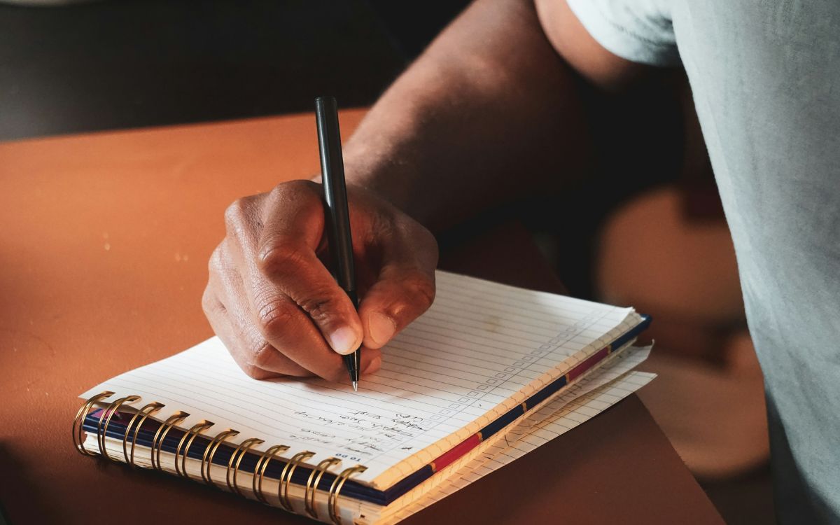 Arte y desarrollo personal: cómo crecer por dentro cuando creas por fuera persona escribiendo en un cuaderno para arte y desarrollo personal